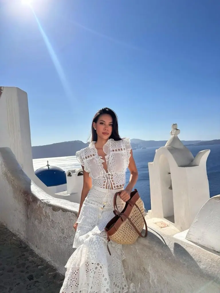 white lace midi dress with puff sleeves and woven bag on white terrace outfit 15