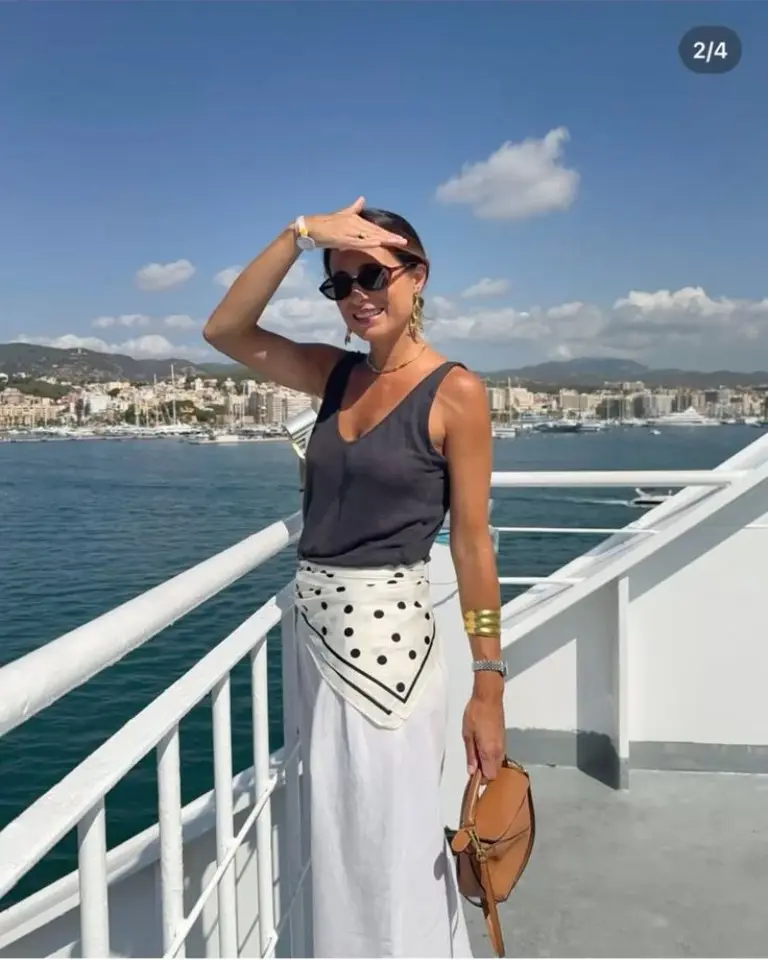 black tank top with white polka dot sarong skirt and brown saddle bag on boat deck outfit 16