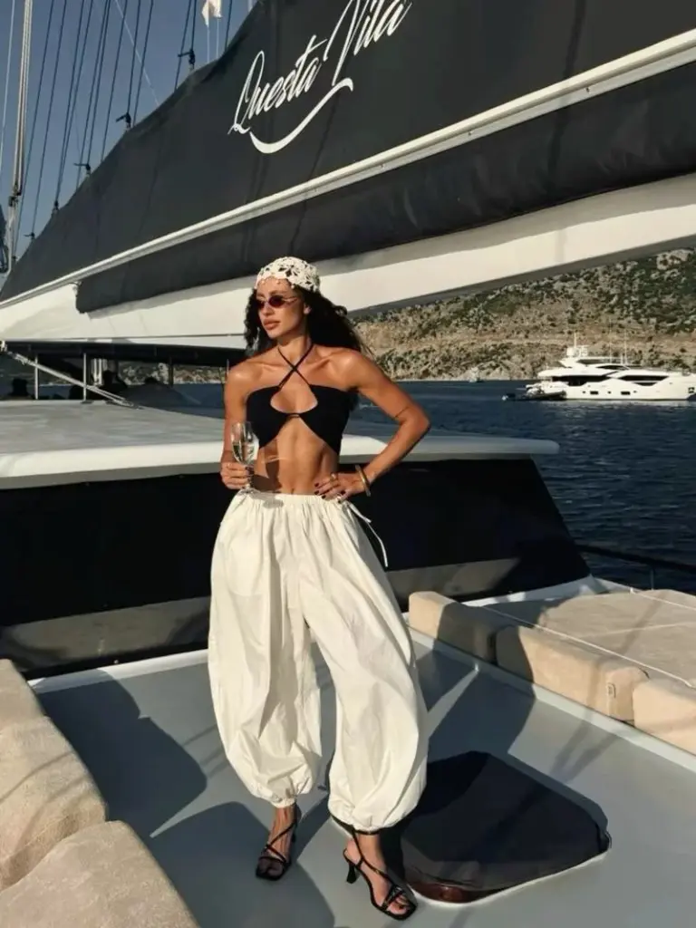 black halter crop top with white wide leg pants and patterned headband on yacht outfit 20