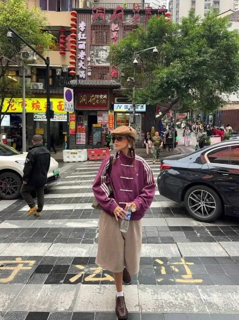 woman in burgundy toggle coat beige wide leg trousers brown beret crossbody bag street style outfit 1