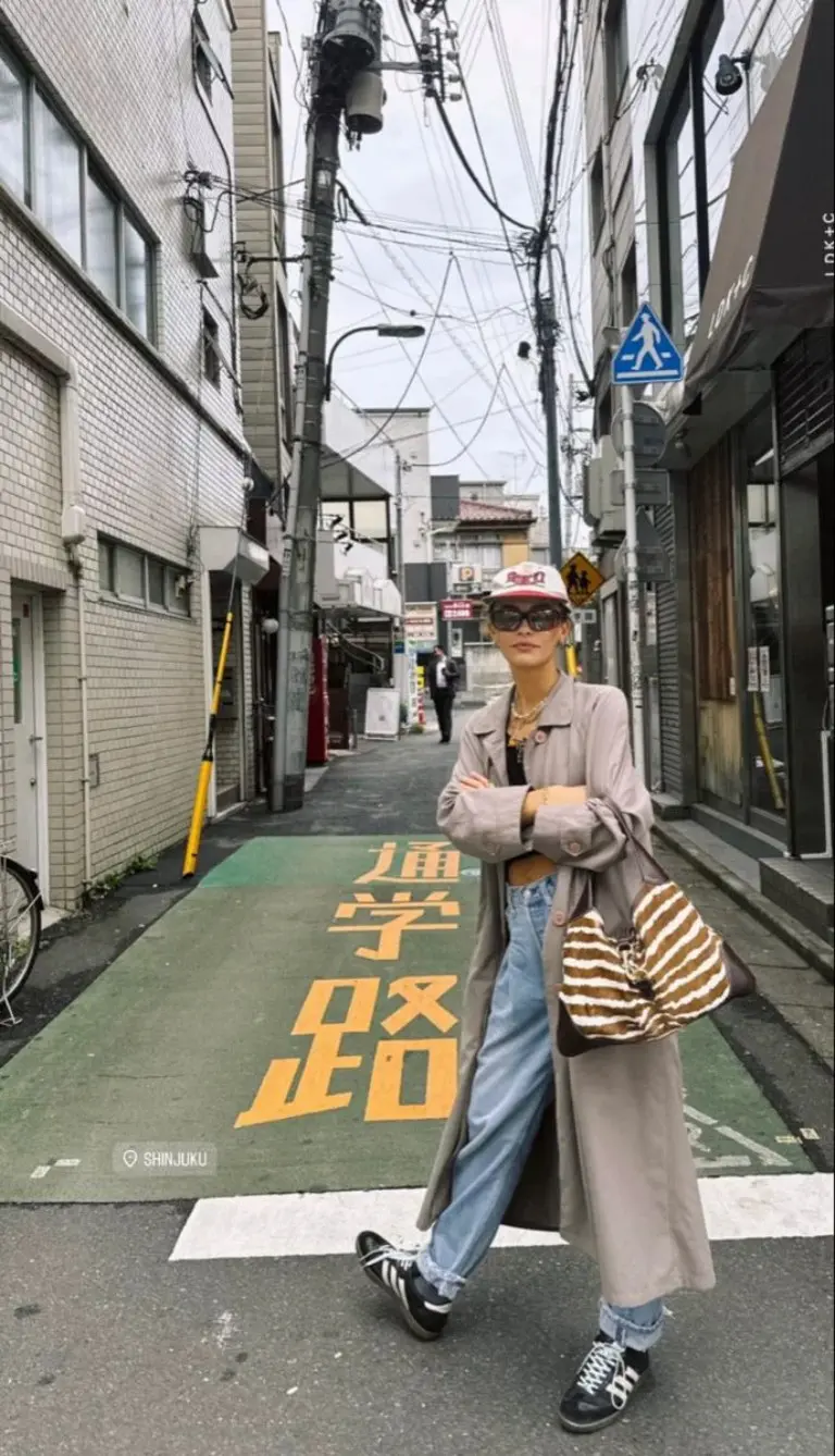 woman in beige oversized blazer blue jeans zebra print bag baseball cap casual street outfit 2