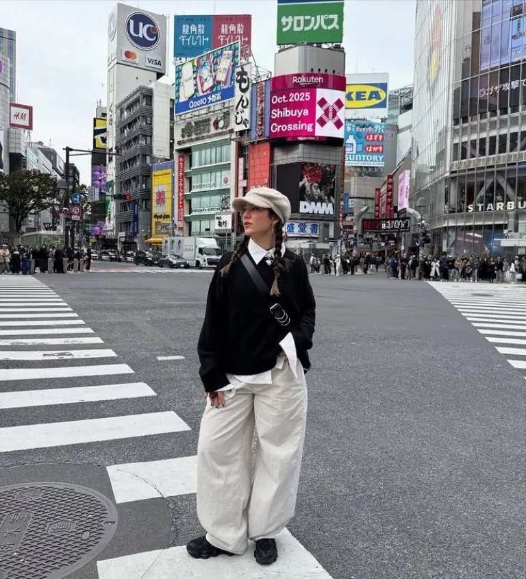 woman in black sweater vest white collared shirt cream wide leg pants black beret busy city crossing outfit 7