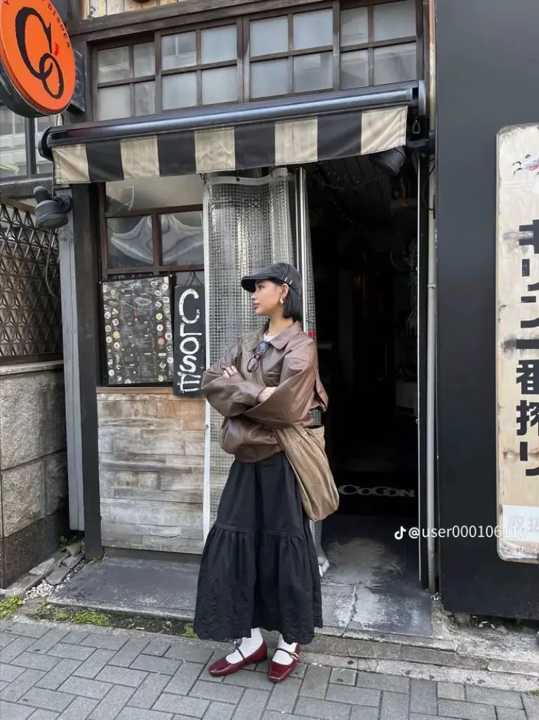 woman in black bomber jacket black midi skirt black strappy sandals sunglasses urban street vending machines outfit 10