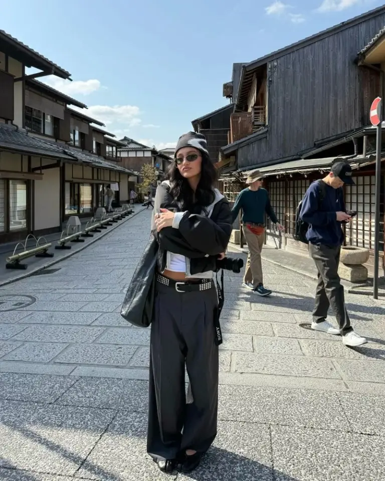 woman in black striped turtleneck long black coat bright yellow sneakers train interior outfit 12
