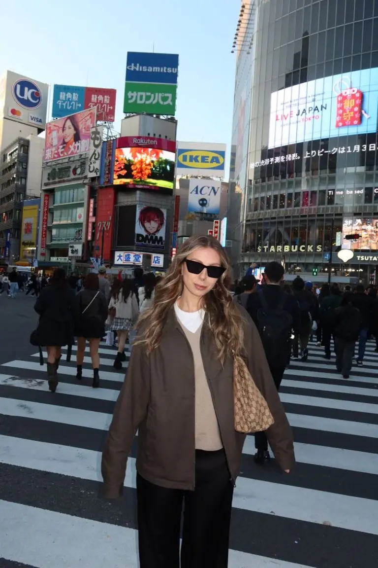 woman in black leather jacket striped sweater blue denim skirt black tote bag cherry blossoms background outfit 14