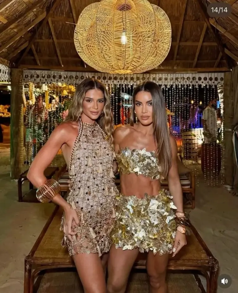 two women in tiki bar wearing gold sequin mini dress and beaded halter crop top outfit 9