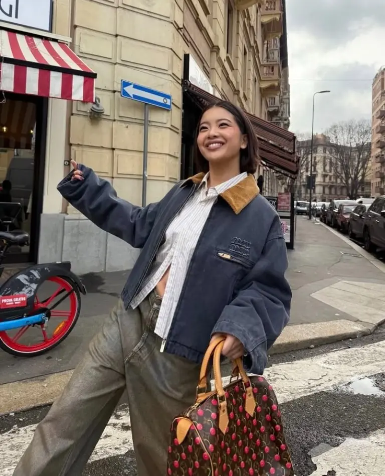 woman in brown oversized cardigan black wide leg pants brown oxford shoes shopping street traditional buildings outfit 19