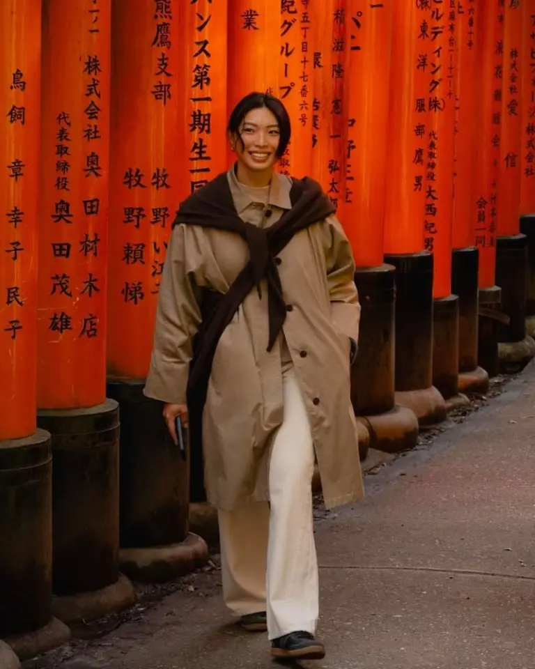 woman in beige oversized blazer black wide leg pants brown crossbody bag busy city street mixed architecture outfit 20