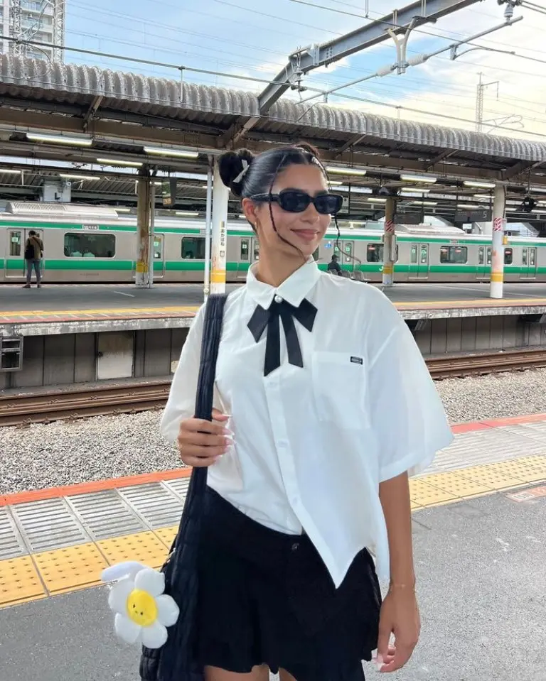 white oversized shirt with bow detail black pleated mini skirt black tote bag train platform outfit 15