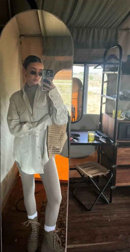 woman in beige linen safari shirt white pants woven bag hiking boots airstream trailer outfit 1