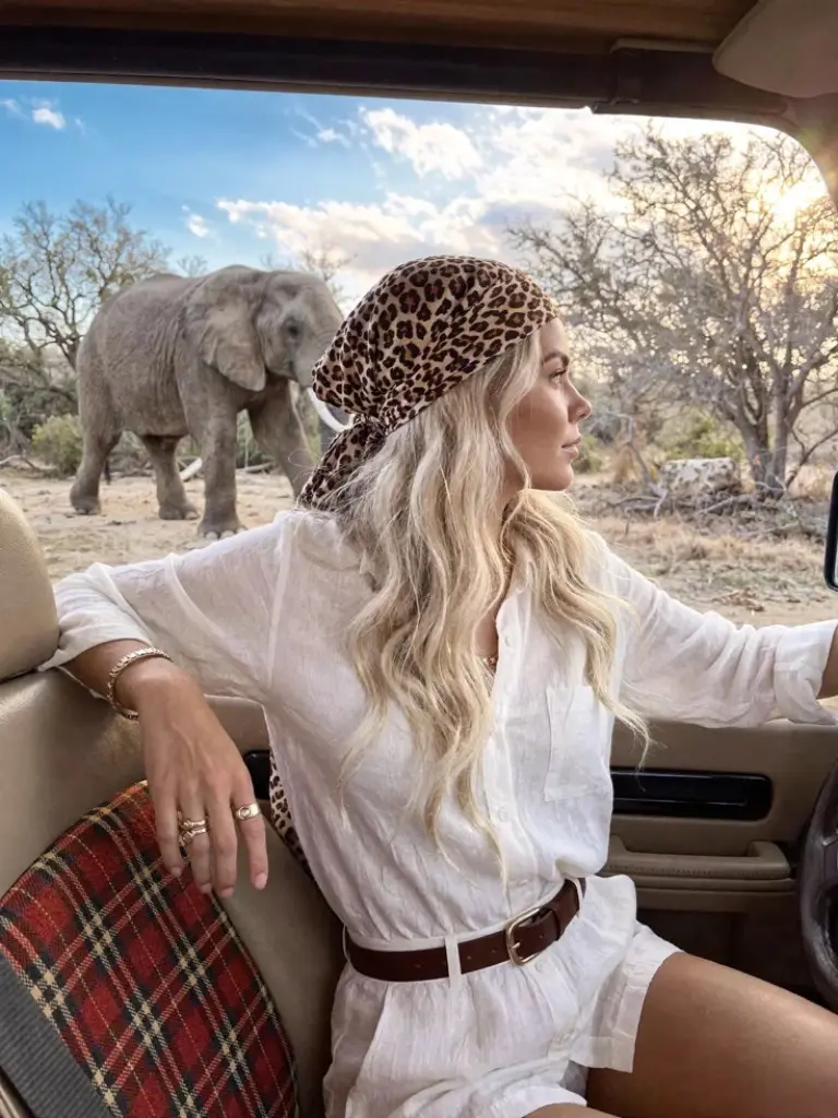 white linen dress brown leather belt leopard print headscarf safari vehicle elephant background outfit 3
