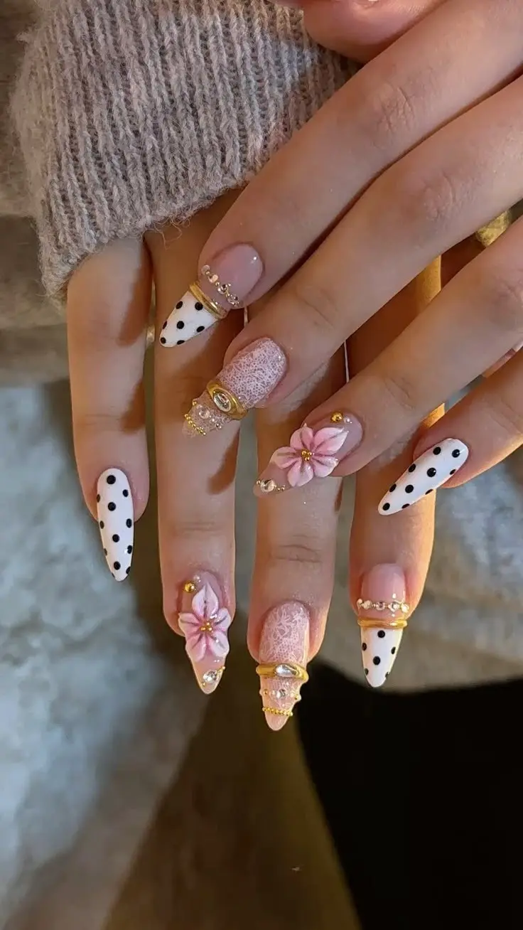 long stiletto nails in mixed set white black polka dot sheer pink lace texture nude base with 3D sculpted pink flower and gold ring band charm with crystal drops photo 13