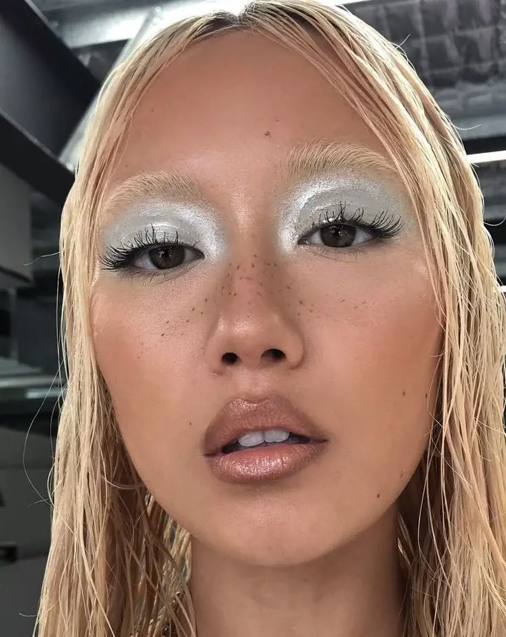 blonde woman with silver chrome eyeshadow covering full lid natural skin freckles nude gloss lip cold girl makeup look 2