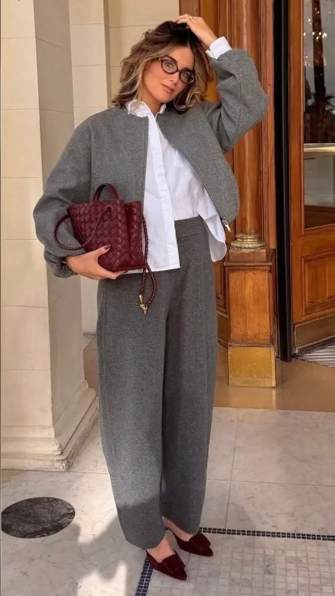 woman in grey wool bomber co-ord jacket and wide trousers white poplin shirt burgundy woven mini bag burgundy velvet mule slides glasses fall work outfit 10