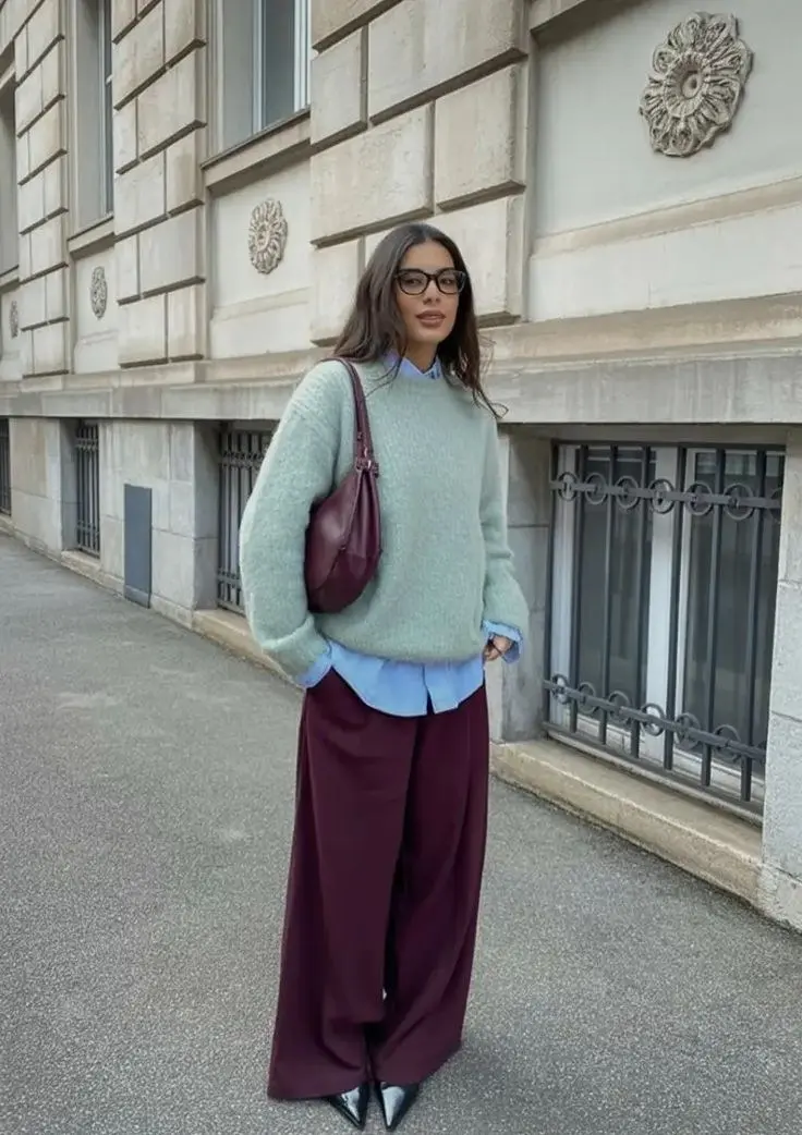 woman in mint green oversized knit sweater light blue collar shirt visible deep burgundy wide leg tailored trousers silver metallic pointed boots burgundy shoulder bag glasses street fall work outfit 17