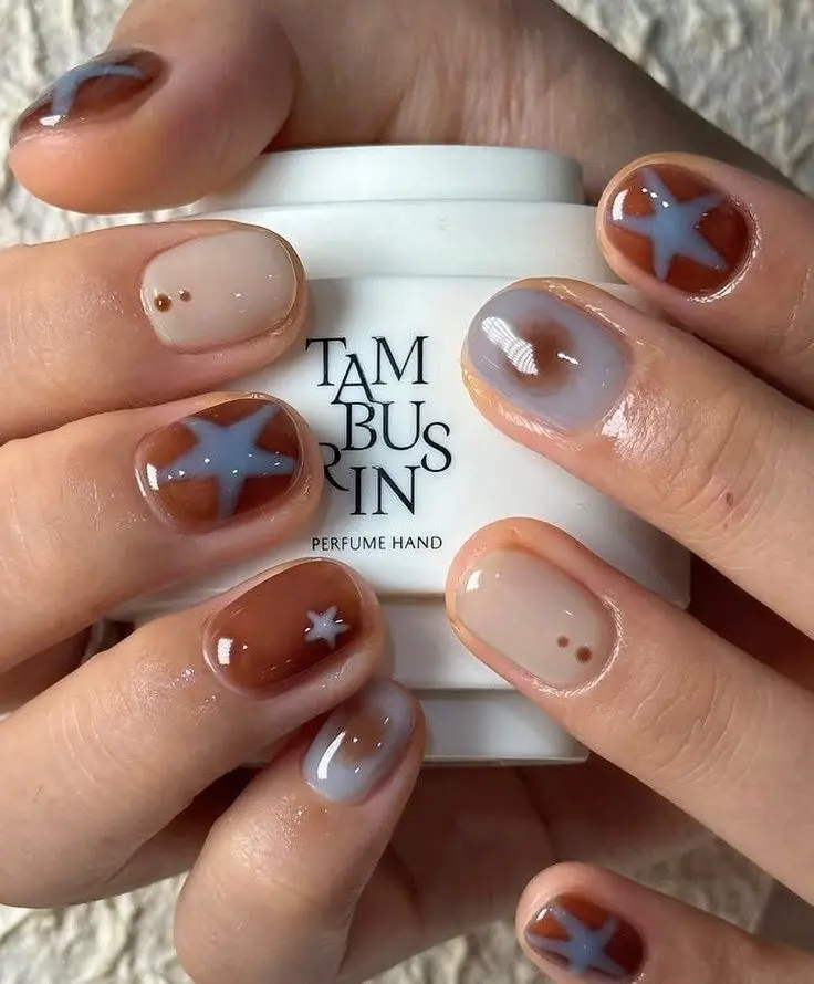 short round nails mixed rust orange and periwinkle grey gel with sheer nude accent nails periwinkle stars and gold micro dots photo 9