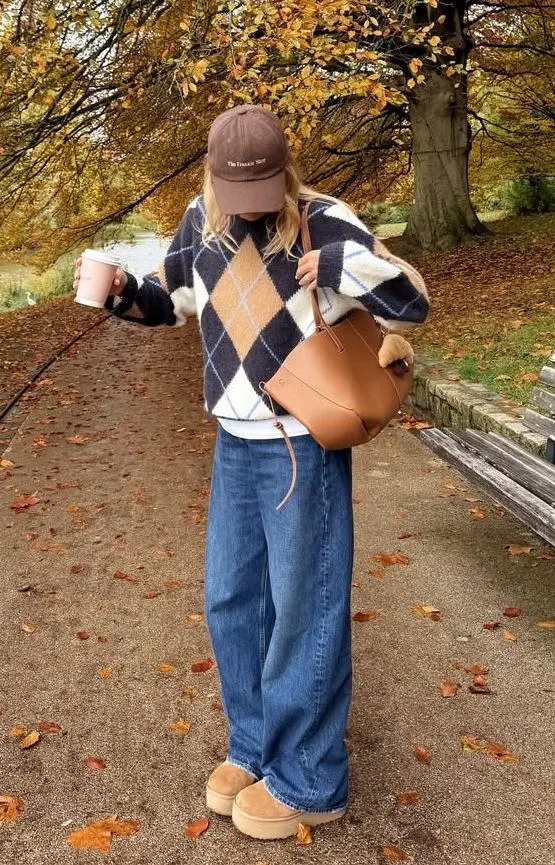 woman in argyle navy camel white sweater white tee wide leg mid wash jeans platform UGG boots brown baseball cap cognac bucket bag autumn leaves pumpkin patch outfit 9