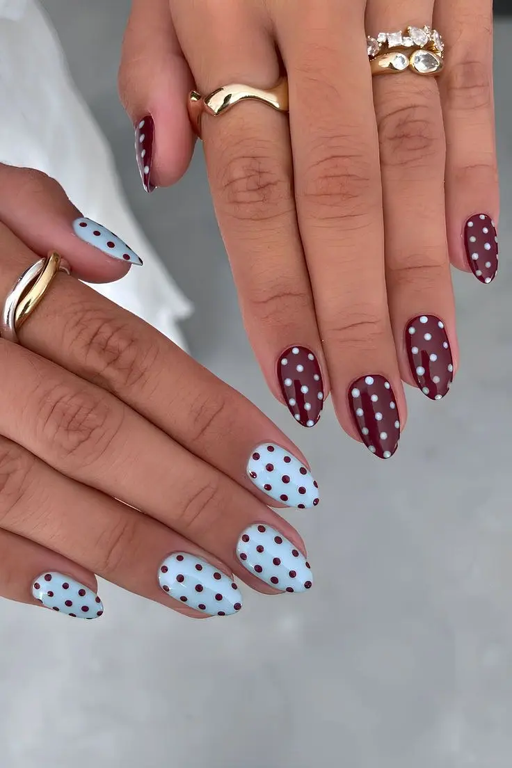 almond nails with burgundy oxblood base and white polka dots on one hand, baby blue base with burgundy polka dots on the other hand, photo 1