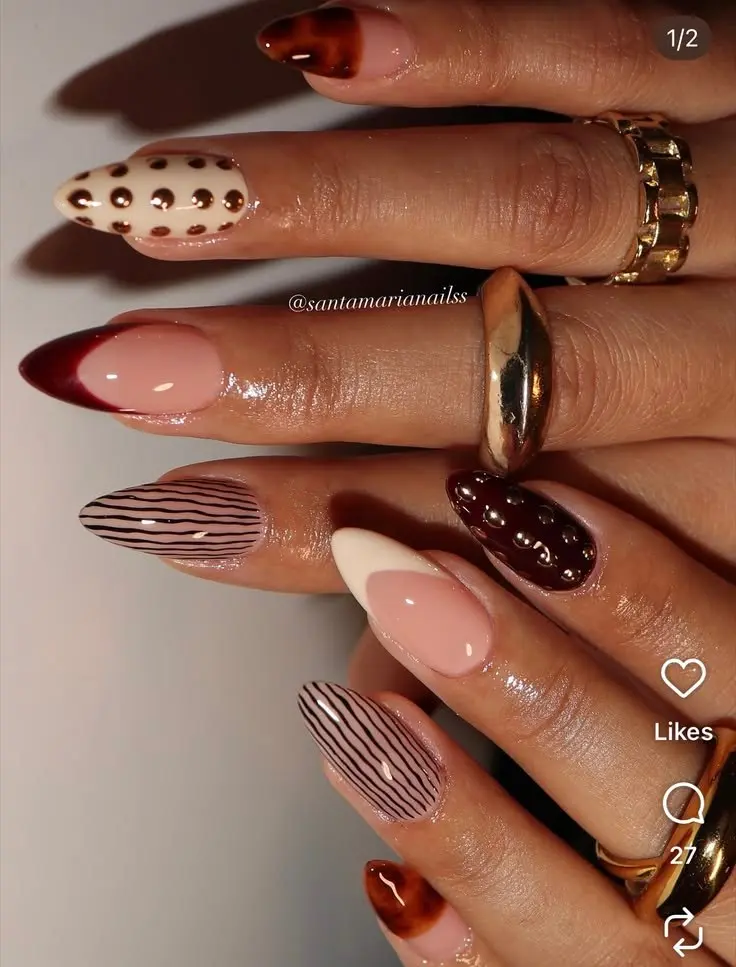 medium almond nails in cream, nude, and burgundy with mixed nail art including 3D pearl dots, fine black pinstripes, tortoiseshell tips, and raised bubble texture details, photo 11