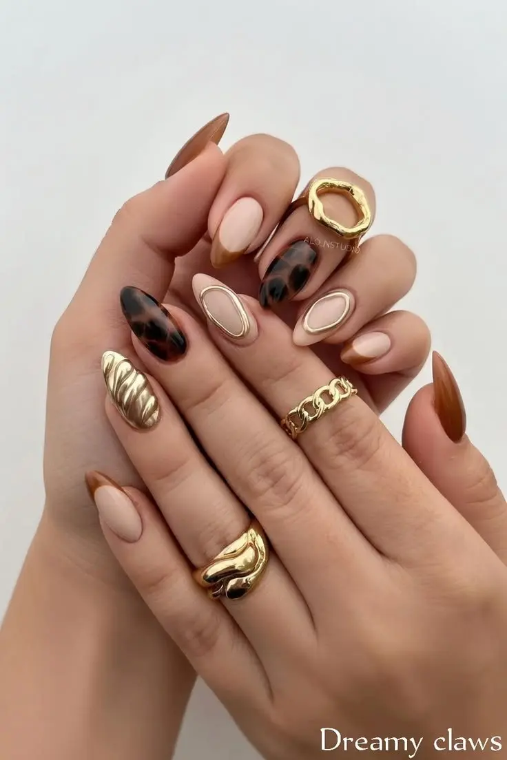 almond nails with mixed fall techniques including 3D metallic gold wave nail, tortoiseshell amber and black nail, matte nude nails with gold oval outline, and sheer caramel solid nail, photo 17
