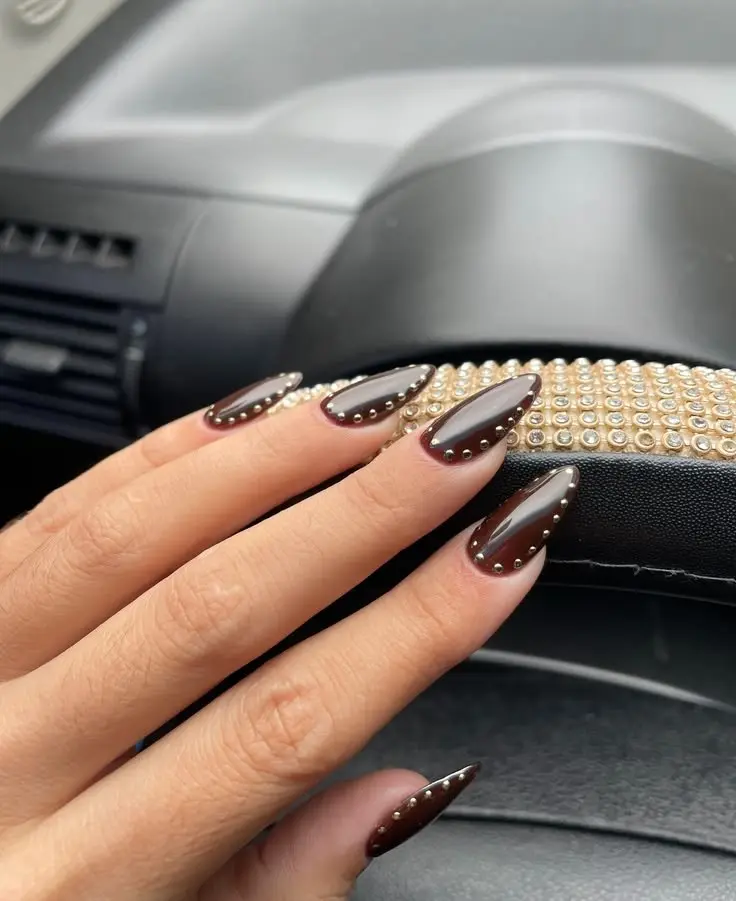 long almond nails in deep oxblood burgundy gel with silver micro-stud border along cuticle line and sides of each nail, high gloss finish, photo 18