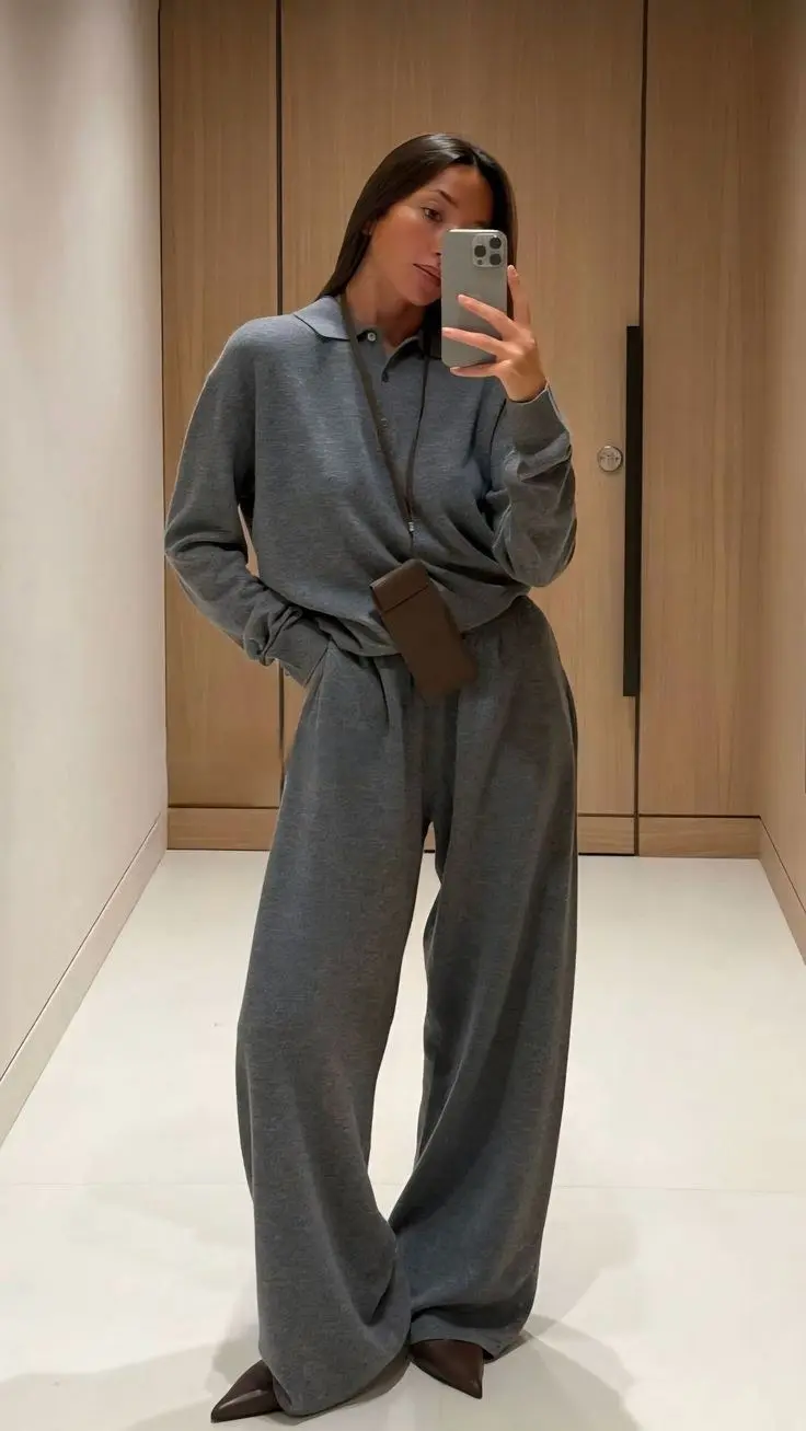 Heather gray suit blazer with pleated trousers, white shirt underneath, worn open-collar, chunky loafers, urban backdrop fall
