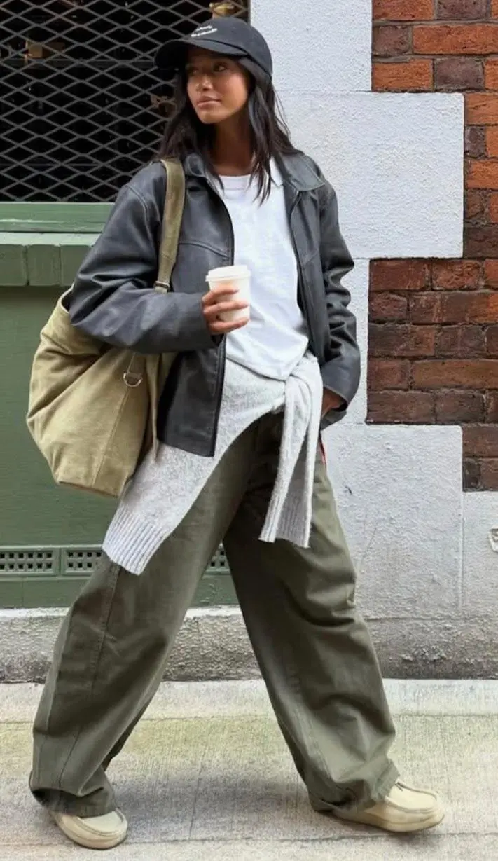 Black utility cargo trousers with oversized bomber jacket and chunky combat boots, city sidewalk autumn light