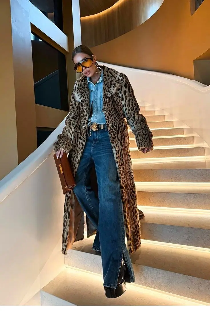 Leopard print mid-length coat worn over all-black outfit — black turtleneck, black straight-leg jeans, black ankle boots, street style fall