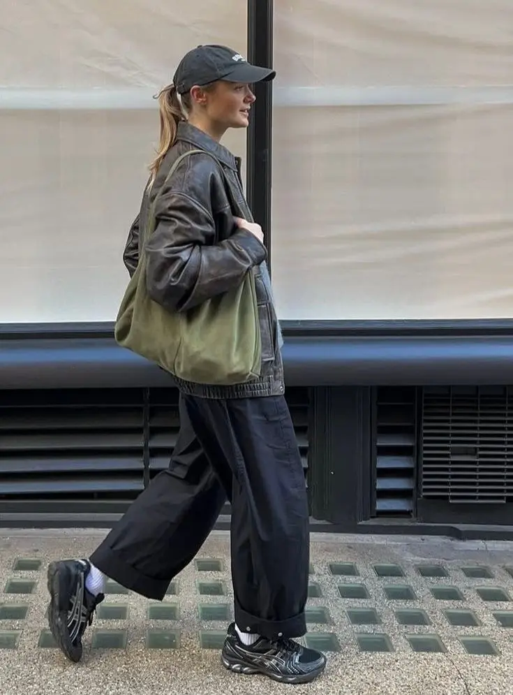 Arc'teryx-style technical shell jacket over tailored wide-leg trousers and a white knit, trail sneakers, urban fall street style