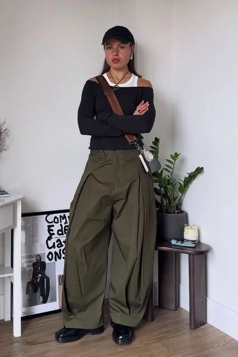 Quilted vest layered over blazer over ribbed turtleneck, dark wide-leg trousers, clean retro runners, gorpcore city editorial