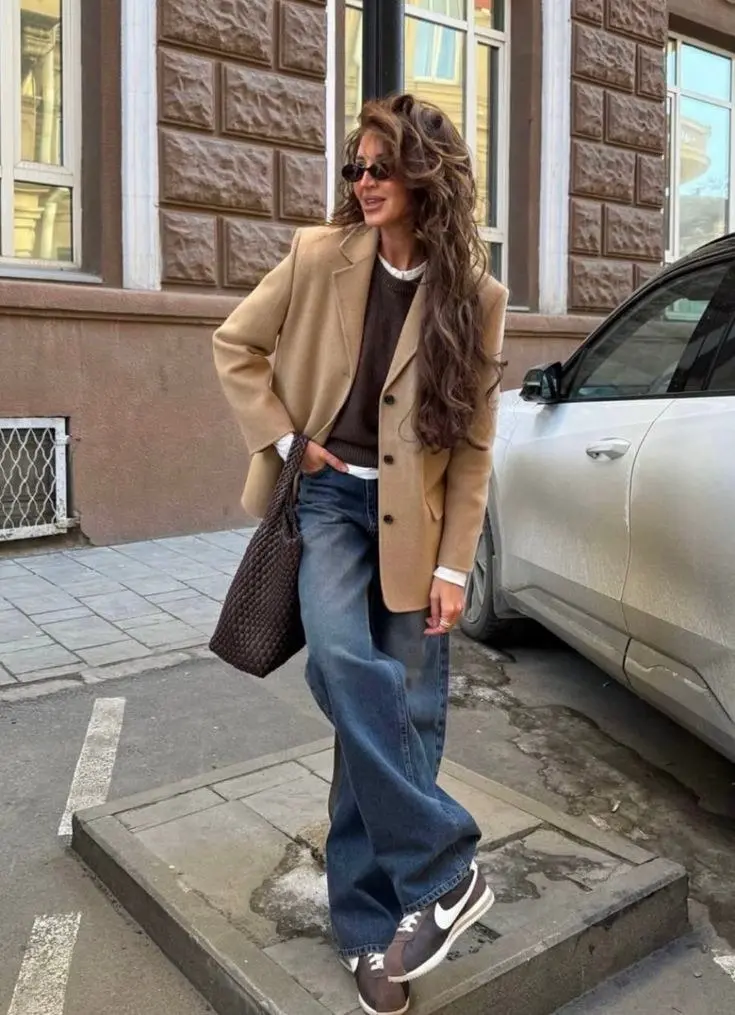 Vintage reissue leather sneaker styled with a long wool coat over wide-leg trousers, retro runner fall street style