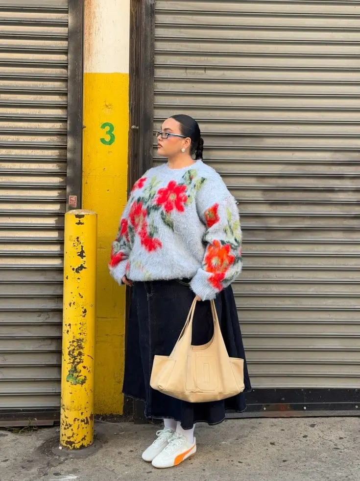 Curvy woman in oversized cream chunky knit sweater, dark straight-leg jeans, knee-high boots, warm fall afternoon