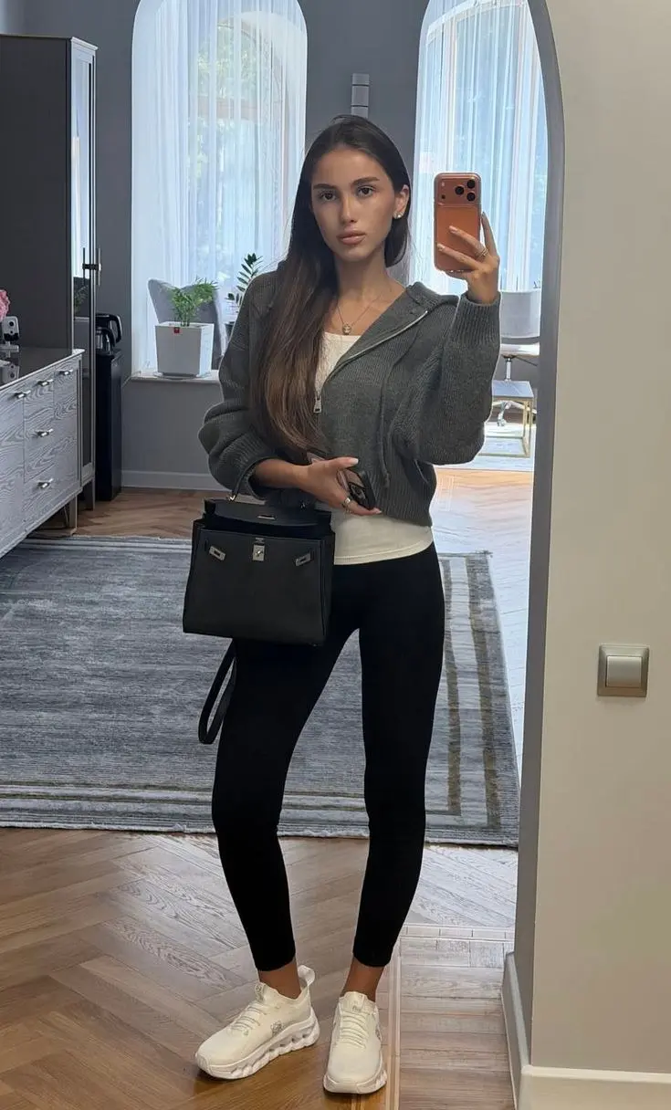 brunette woman in charcoal zip knit cardigan white tank top black leggings white On Cloud sneakers small black structured top-handle bag mirror selfie outfit 6