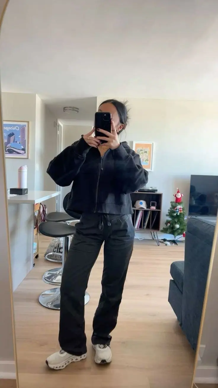 woman in matching black zip cropped hoodie and black wide-leg jogger pants white On Cloud sneakers apartment mirror selfie outfit 10