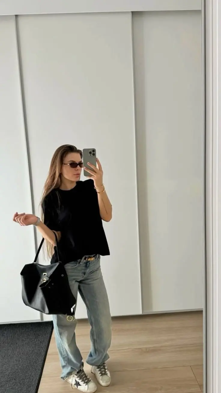 woman in black boxy tee light wash straight jeans large black leather bag white distressed sneakers mirror selfie photo 3