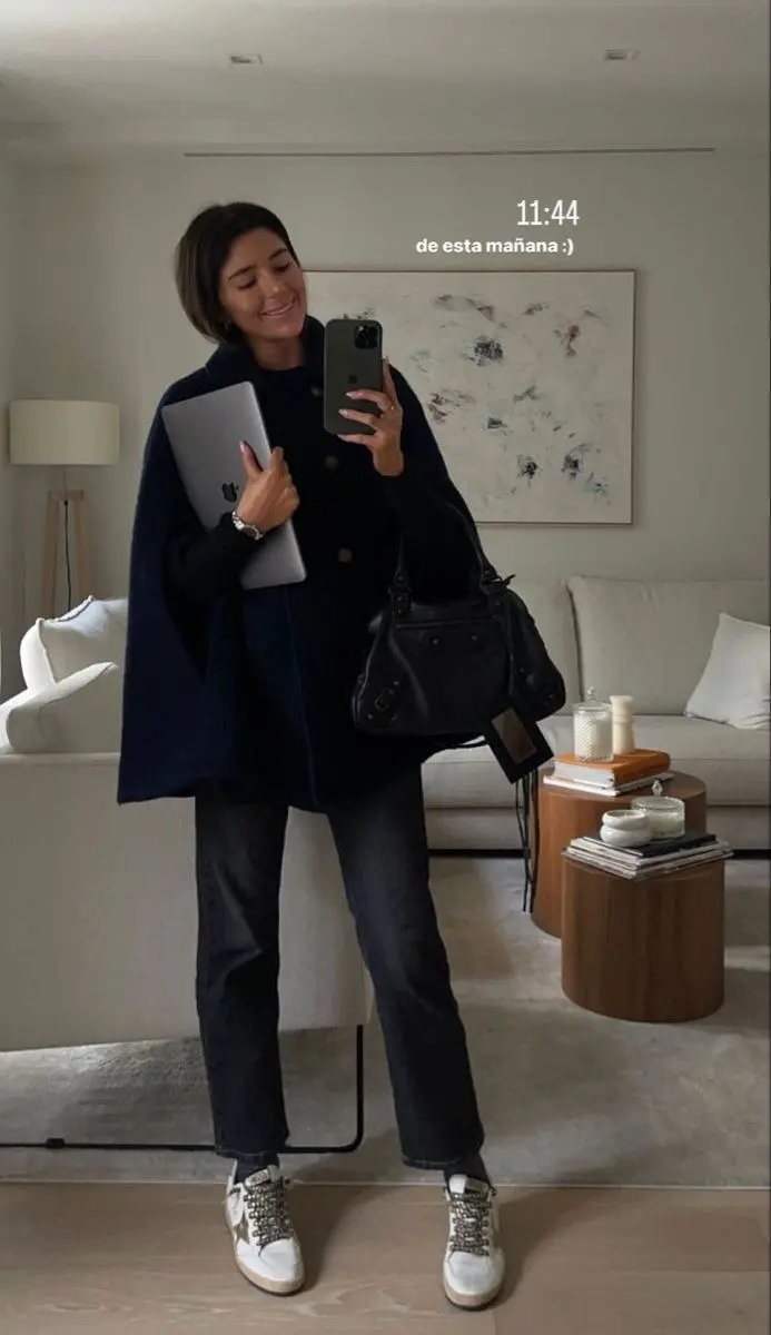 woman in navy wool cape coat black knit dark jeans white distressed star sneakers black structured bag mirror selfie photo 7