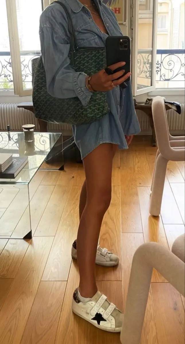 woman in oversized denim shirt worn as dress white velcro strap distressed sneakers printed canvas tote bag mirror selfie photo 9