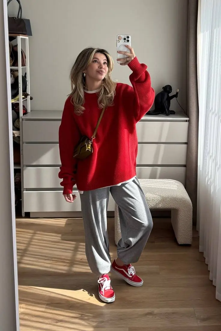 blonde woman in red oversized crewneck knit sweater white tee grey sweatpants red Vans Old Skool sneakers camel crossbody bag mirror selfie home outfit 21