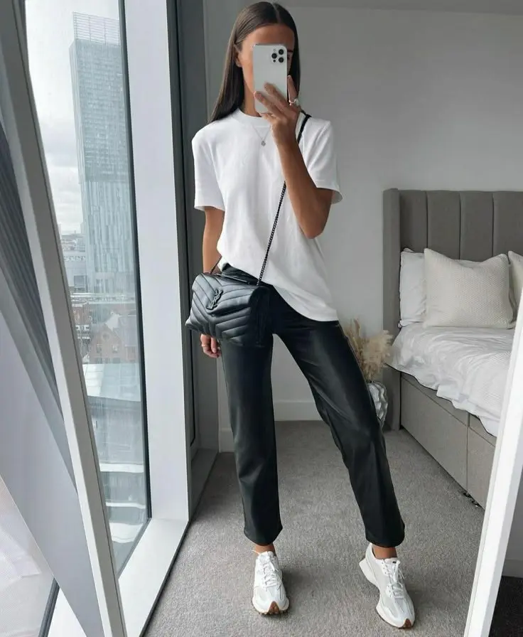 woman in white oversized tee black faux leather straight trousers white New Balance sneakers small black quilted crossbody bag mirror selfie outfit 11