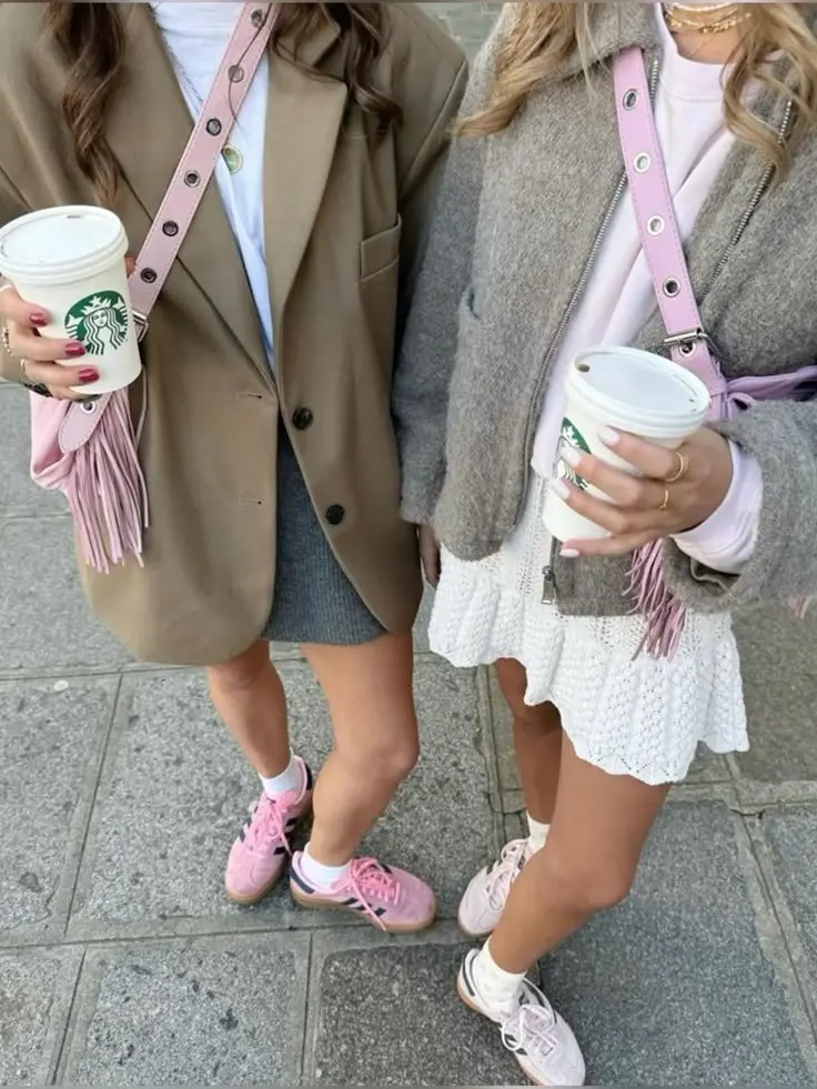two women from waist down, one in camel oversized blazer over gray denim mini skirt, one in heathered gray knit jacket over white lace mini skirt, both in pink sneakers with white socks and pink fringed crossbody bags, photo 10