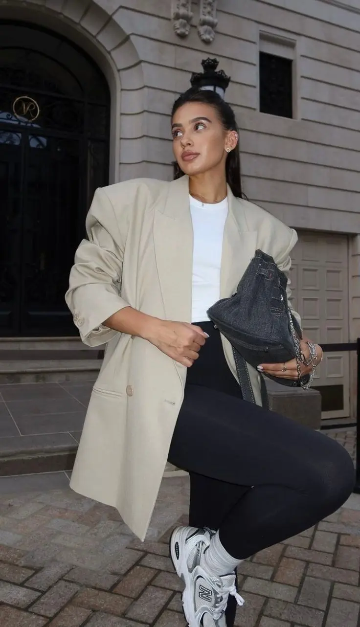 woman wearing oversized beige blazer white tee black leggings New Balance 530 sneakers denim chain bag outfit 1