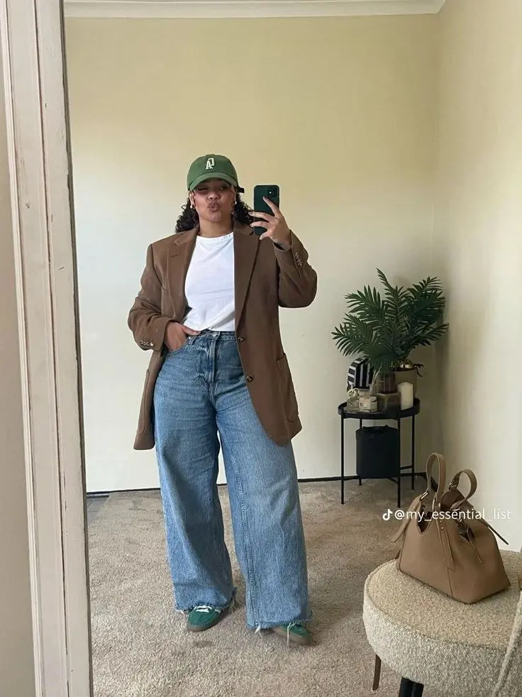 curvy woman in brown oversized blazer white tee wide leg light wash jeans green cap and green sneakers mirror selfie outfit 4