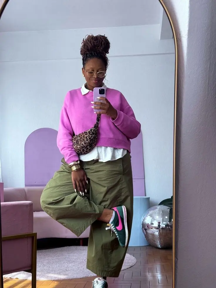 curvy woman in pink crewneck sweater over white collared shirt olive cargo wide leg trousers leopard belt bag and green pink sneakers mirror selfie outfit 6