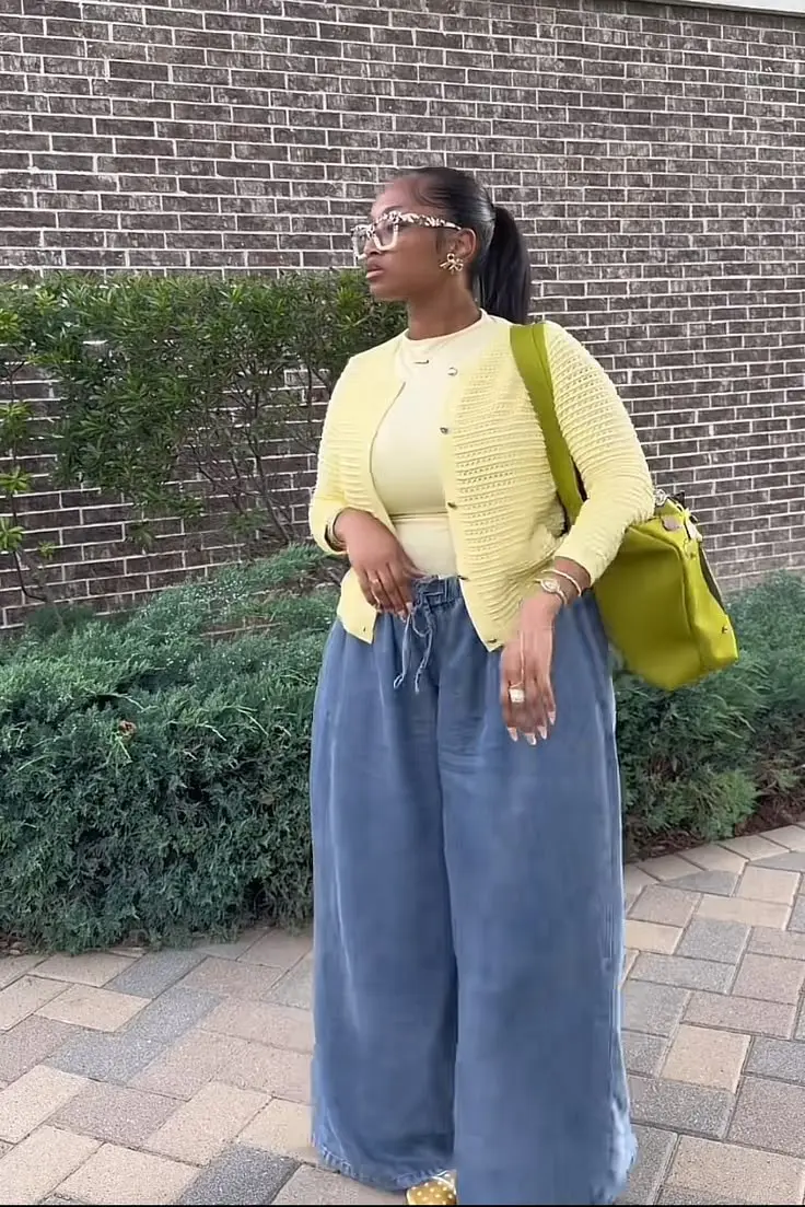 woman in yellow knit button front cardigan pale yellow top wide leg steel blue chambray trousers chartreuse structured shoulder bag yellow polka dot mule flats floral print sunglasses gold jewelry outfit 20
