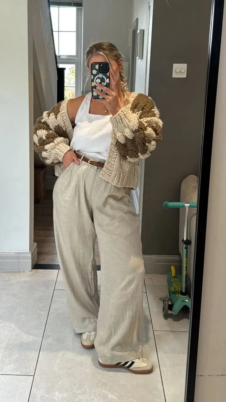 woman in chunky textured two tone knit oversized cardigan white cami top natural linen wide leg trousers tan leather belt adidas samba sneakers mirror selfie hallway outfit 21