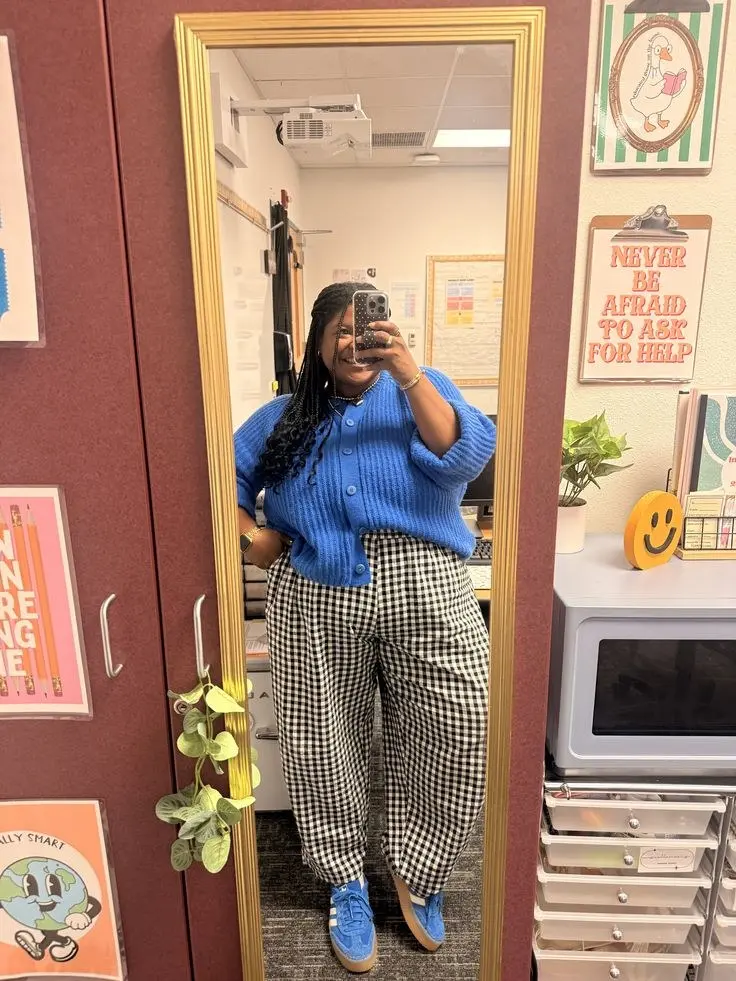 curvy woman in cobalt blue cardigan black white gingham balloon trousers blue sneakers pearl necklace classroom mirror selfie outfit 4