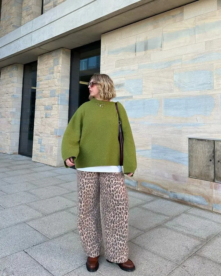 curvy woman in oversized olive green sweater white layer leopard print wide leg trousers brown chunky platform boots brown crossbody bag sunglasses street style outfit 8