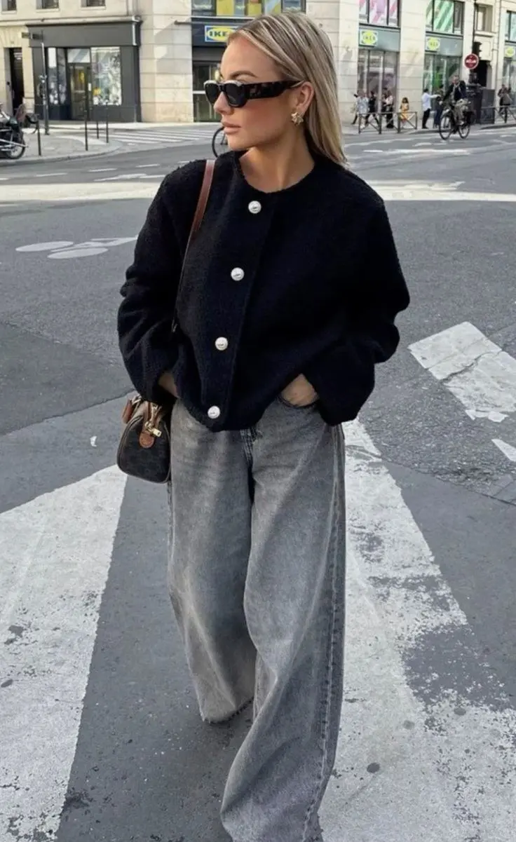 blonde woman in black boucle pearl button cardigan light grey wide leg jeans brown shoulder bag sunglasses street outfit 2