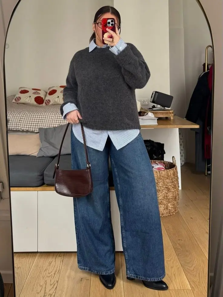 woman in grey oversized knit sweater layered over blue striped shirt dark blue wide leg jeans black loafers burgundy croc shoulder bag mirror selfie outfit 7