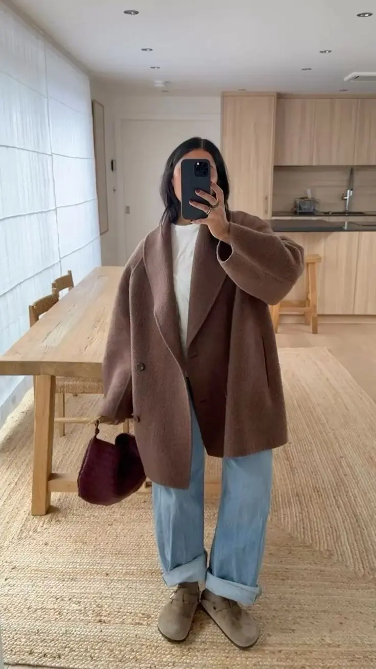 woman mirror selfie in chocolate brown oversized bouclé coat white tee light wash wide leg cuffed jeans taupe suede desert boots small burgundy bag outfit 19